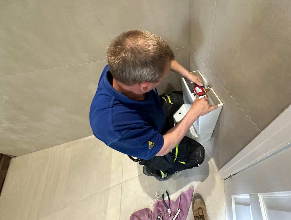 Plumber working on bathroom plumbing