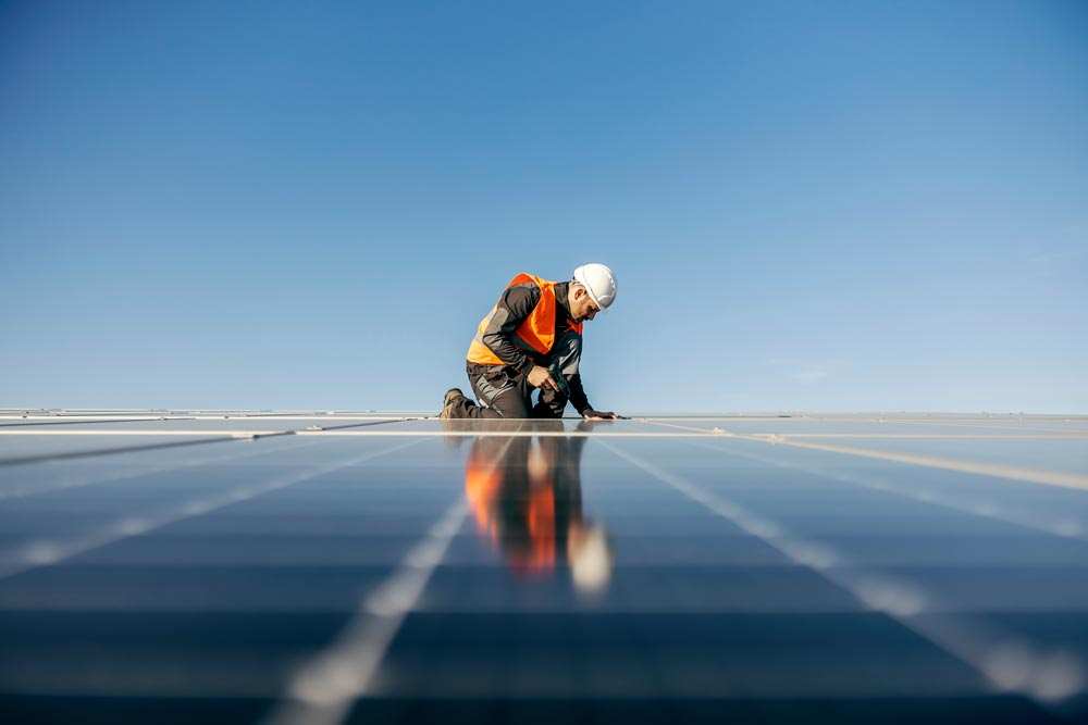 Installers fitting solar panels on a roof