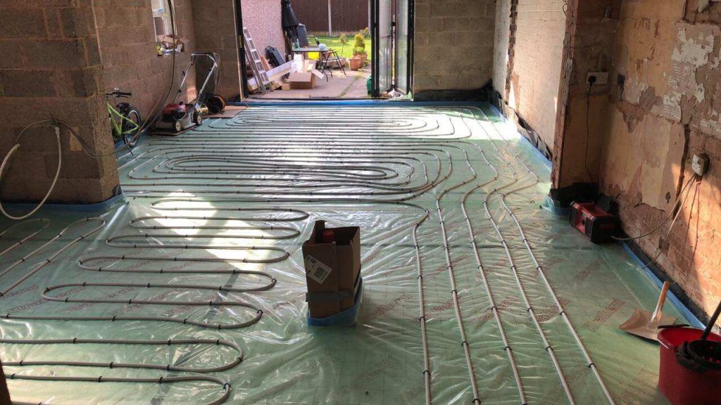 Underfloor heating pipes laid across a floor