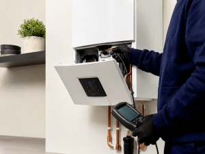 Engineer repairing a boiler with the front panel removed