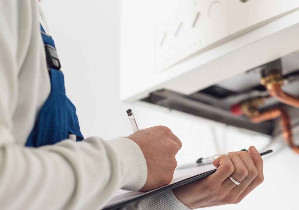 Heating engineer completing a boiler repair checklist